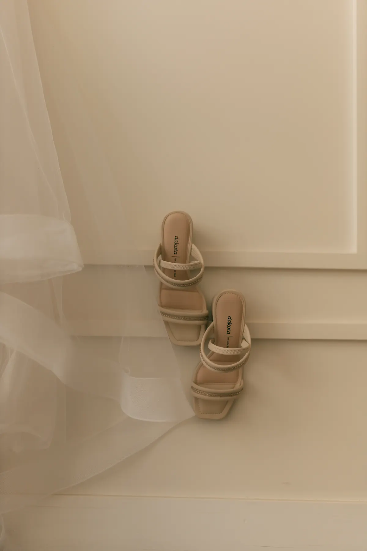 Beige strappy sandals standing in soft morning light